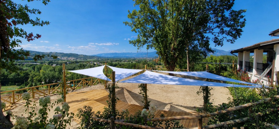 Vele tensili bianche su dehor con vista montagna