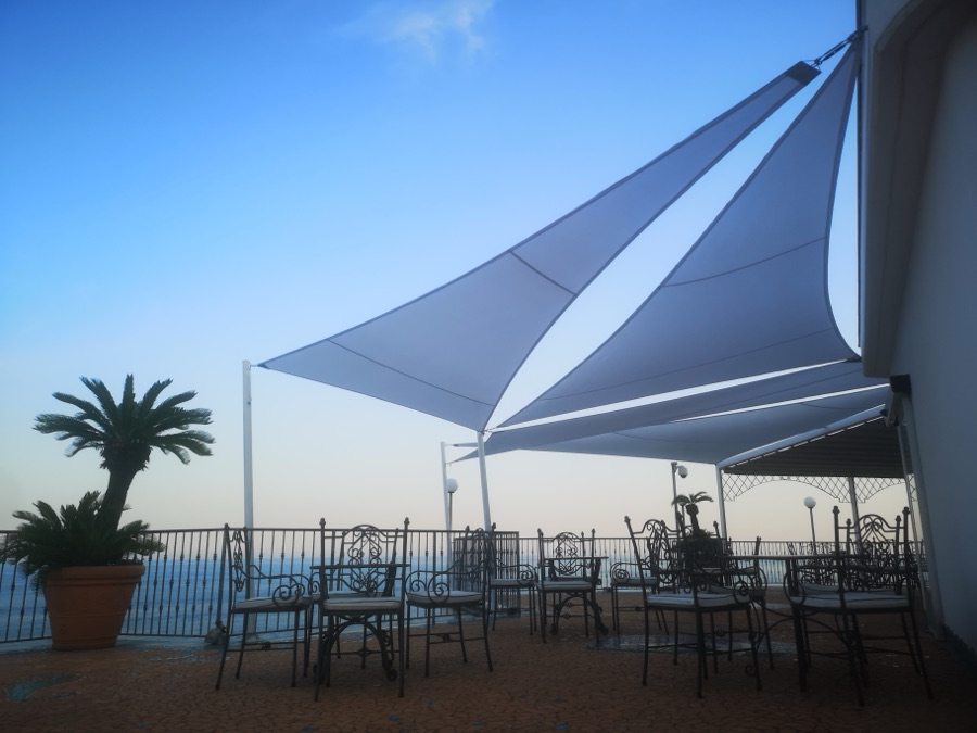 Vele tensili su terrazza al tramonto con vista mare